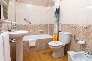Un baño con lavamanos, inodoro, bañera y bidé.