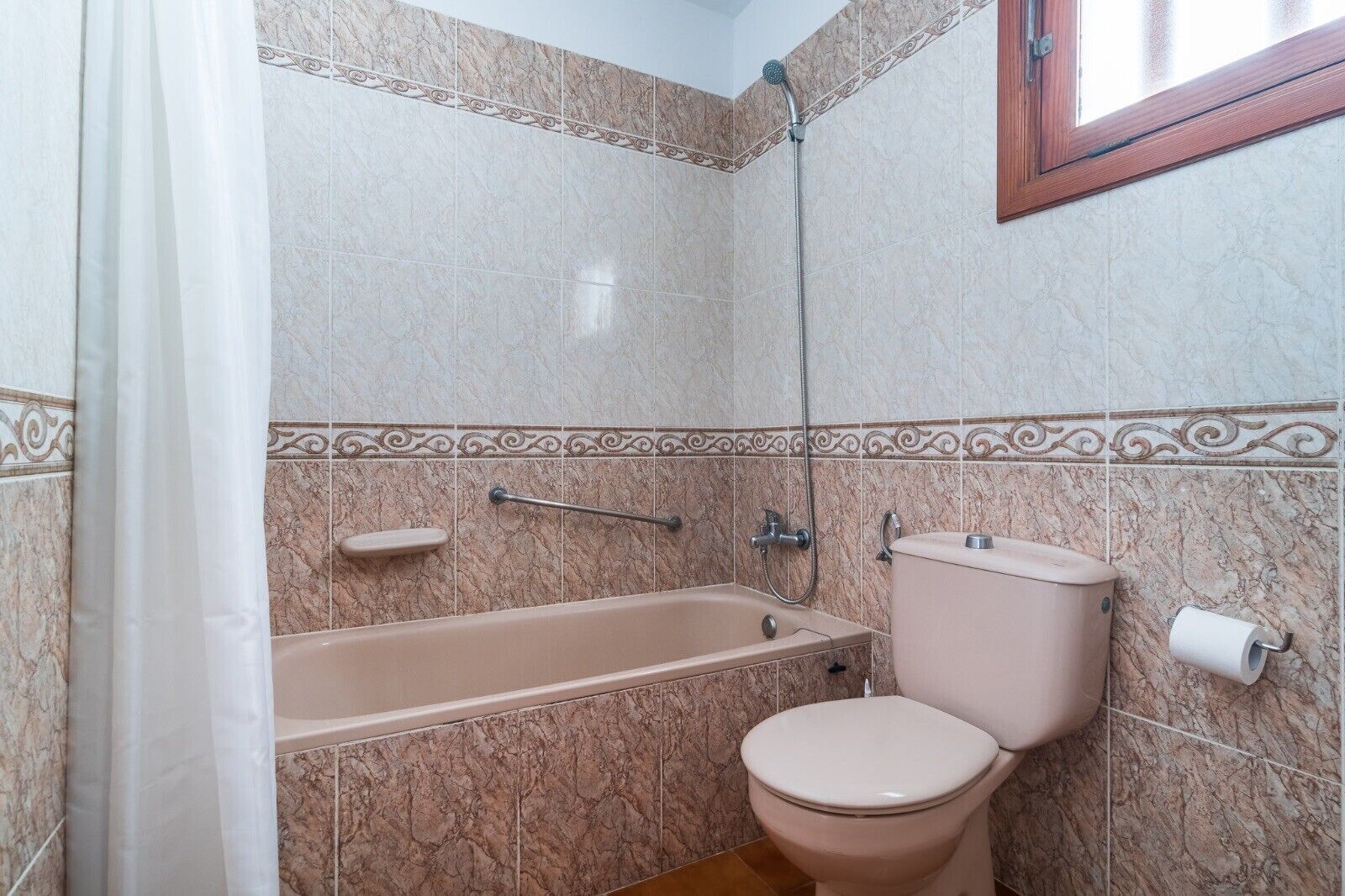 A bathroom with a bathtub, toilet, and shower.