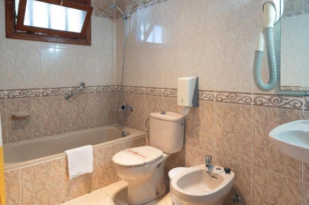 Un baño con bañera, inodoro, bidé y lavabo.