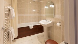 A bathroom with a bathtub, a sink, and a toilet. - Cedars Guest House (Dunoon)