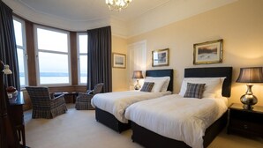 A hotel room with two beds, a desk, and a view of the sea. - Cedars Guest House (Dunoon)
