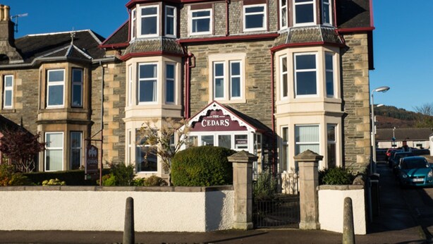 A stone building with a prominent sign reading "The Cedars." - Cedars Guest House (Dunoon)