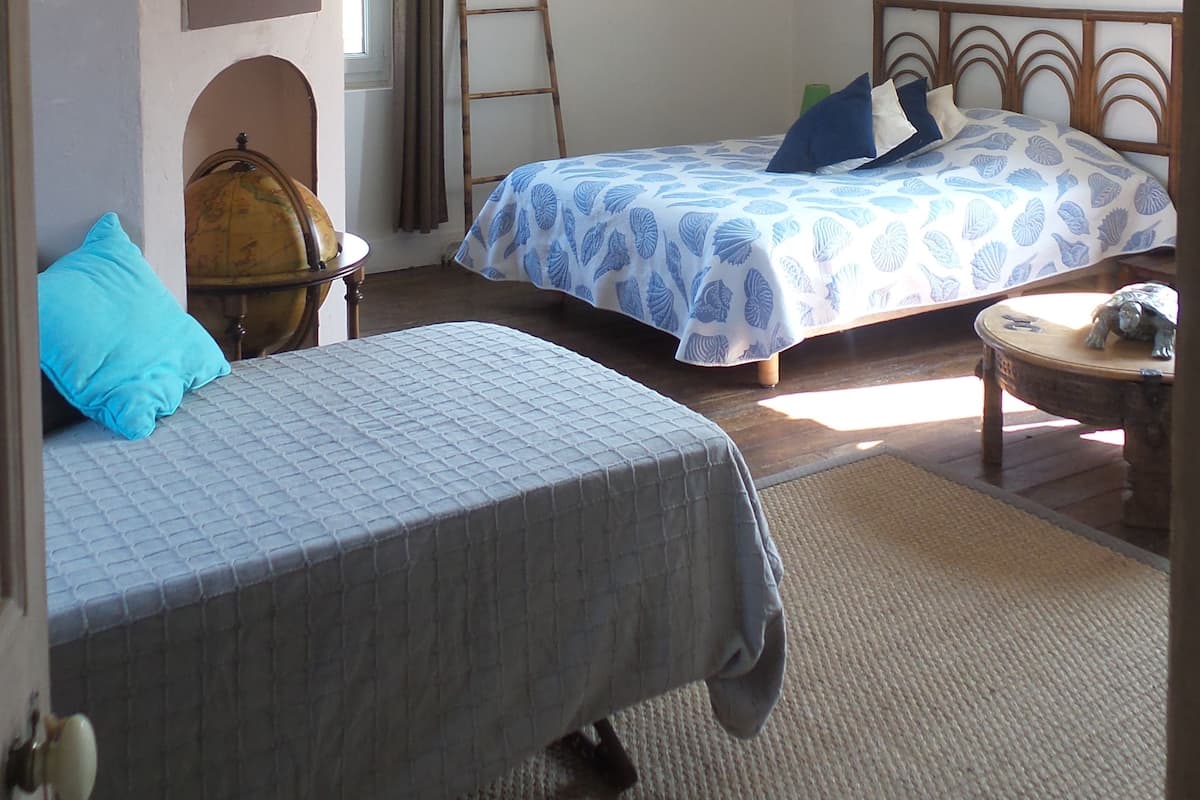 Quarto com duas camas, um globo e um quadro na parede.