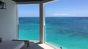 Una habitación con un amplio ventanal que ofrece vista al océano.