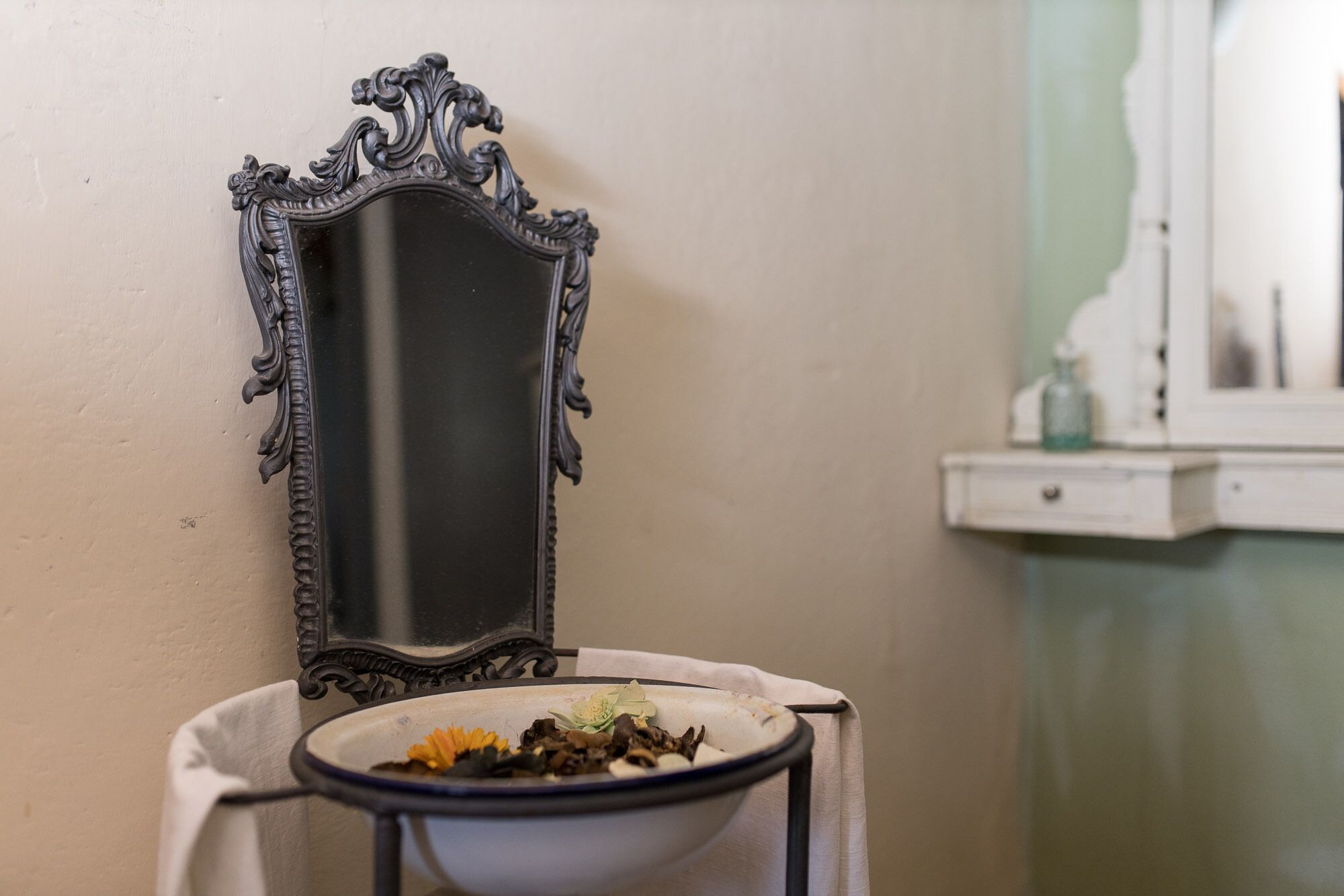 A bathroom with a mirror, a sink, and a towel.