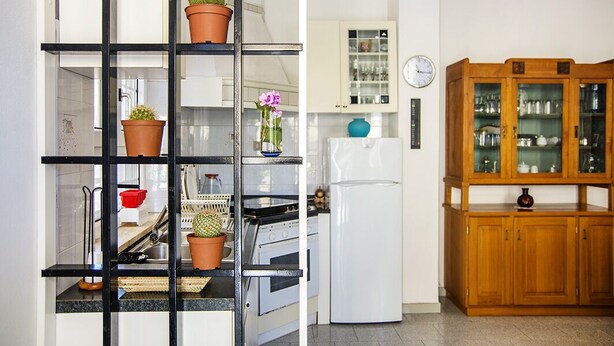 A kitchen with a black metal shelf unit, a white refrigerator, and wooden cabinets. - Manzoni Apartment Le Castella (Le Castella)