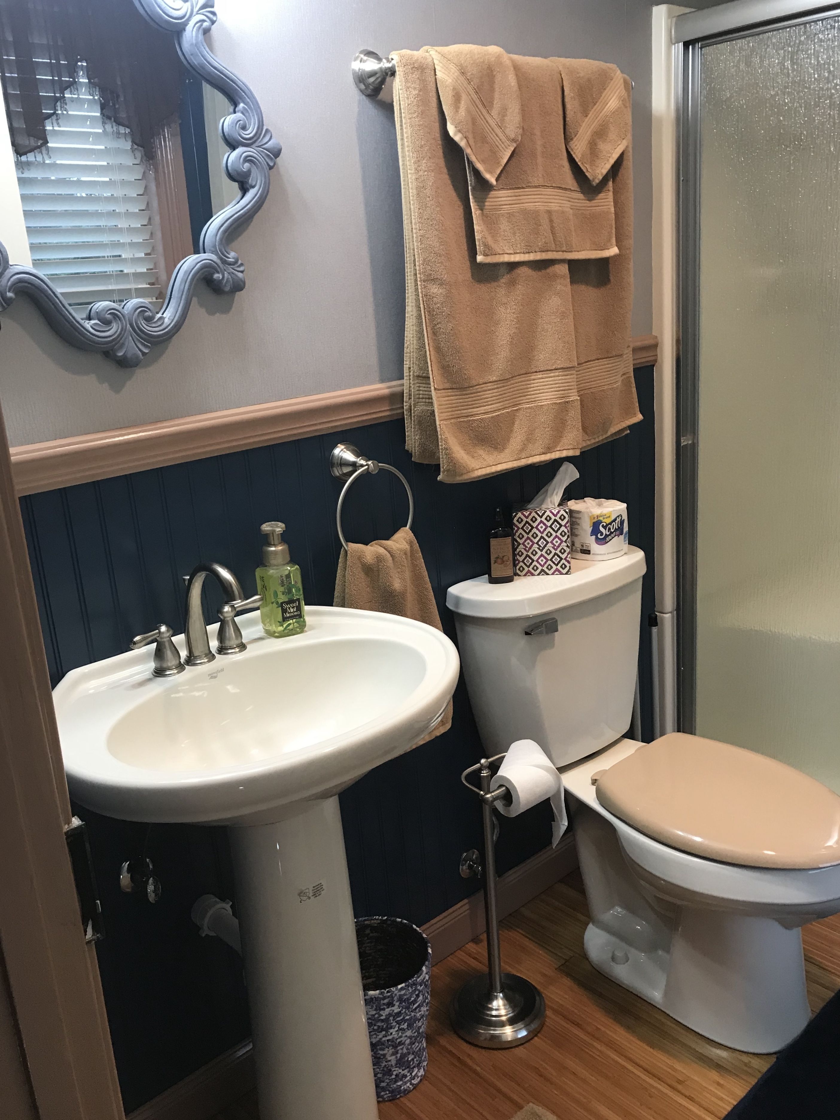 A bathroom with a sink, toilet, and a mirror.
