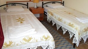 A room with two single beds, a wooden nightstand with a lamp, and a mirror above the bed. - Villa Ozalp Apartments (Ortaca)