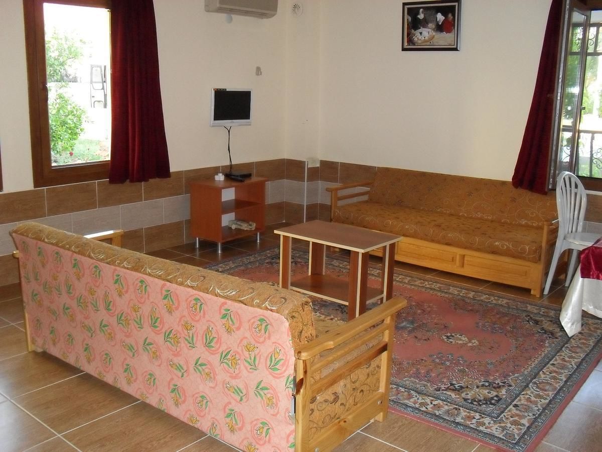Una habitación con sofá, una mesita, una silla y televisión.