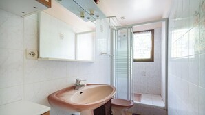 Ein Badezimmer mit Waschbecken, Toilette und Duschbereich.