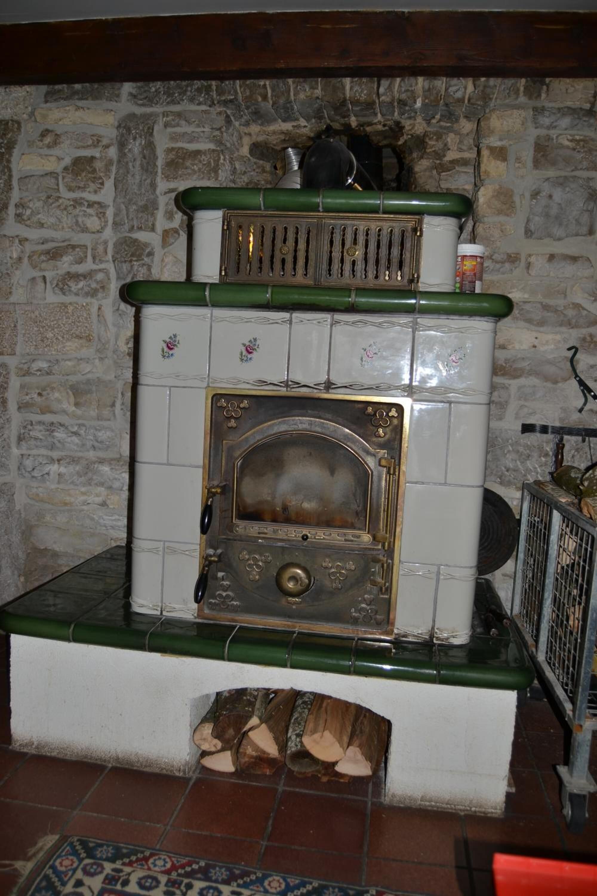 Una pared de piedra con una chimenea que incluye un fuste verde y una puerta decorativa.