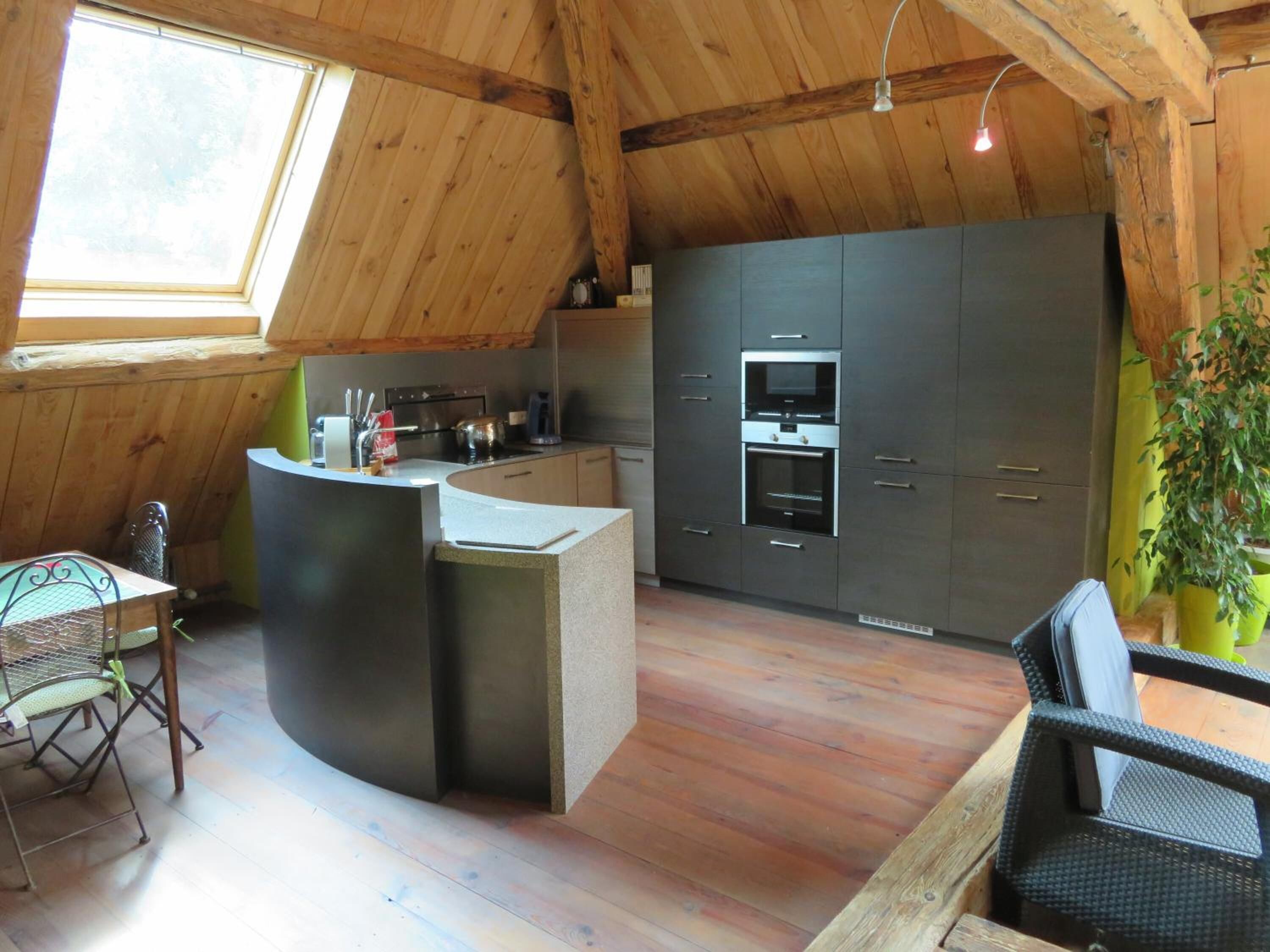 Een moderne keuken met een ingebouwde oven en een groot eiland.