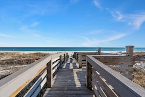 A wooden boardwalk leading to a beach with a clear blue sky. - Shipwatch E603 | Pools & Tennis | Beach Access, Boat Slip | Walk to Florabama | My Beach Getaways (Pensacola)