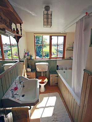 A bathroom with a wooden vanity, a sink, a toilet, and a bathtub.
