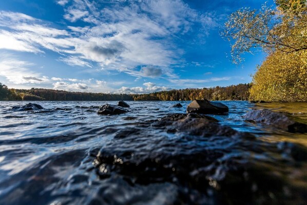 A river with rocks and trees in the background. - Haus am See B&B (Bornheim)