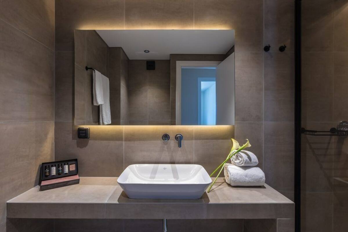 A modern bathroom with a rectangular sink, a towel rack, and a mirror.