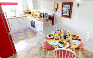 Enjoy meals in this well-equipped kitchen with a dining area for four, featuring a microwave, toaster, and sink.