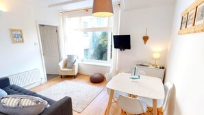 Una sala de estar acogedora con un sofá, una mesita y una ventana con vistas al exterior.