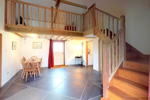Stunning interior with a high ceiling, wooden staircase, and large tile floor.