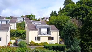 A residential area with multiple houses, each featuring a balcony and a small garden area. - Windermere Lodge 2 Bedrooms (Windermere)