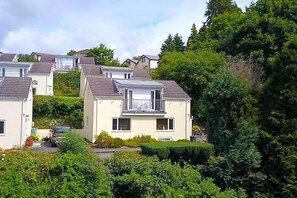 A residential area with multiple houses, each featuring a balcony and a small garden area. - Windermere Lodge 2 Bedrooms (Windermere)