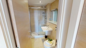 A bathroom with a glass-enclosed shower, a white sink, and a toilet. - Saunton Point Break 2 Bedrooms (Braunton)