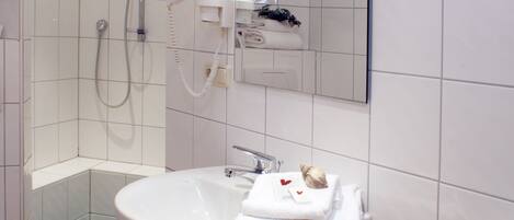 A bathroom with a shower, sink, and toilet.