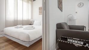 A modern hotel room with a bed, a chair, a lamp, and a wall clock. - Italianway   - Segrino 6 (Milan)