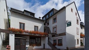 A hotel with a traditional facade, a staircase leading to the entrance, and flower boxes on the windowsills. - Hotel Restaurant Schütz (Trier)