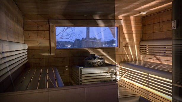 En sauna med trævægge, et vindue og bænke.