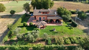 Una casa con techo de tejas, un patio y un jardín.