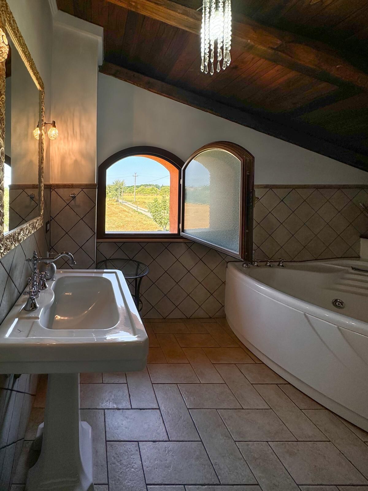 Un baño con lavamanos, espejo, ventana y bañera.