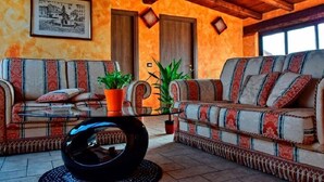 Una sala de estar acogedora con dos sofás, una mesita de centro y plantas en macetas.