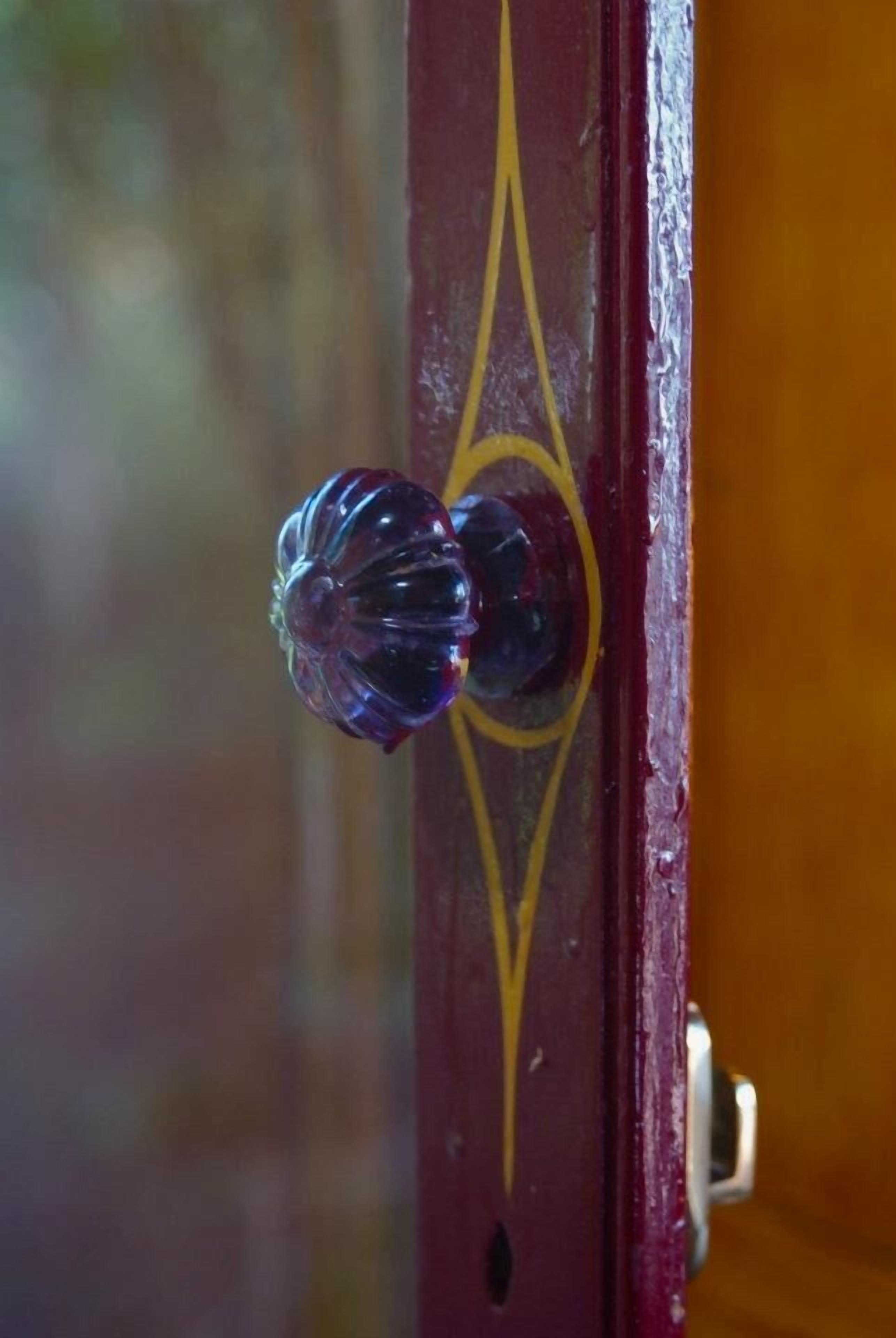 A close-up of a door handle with a decorative glass knob.