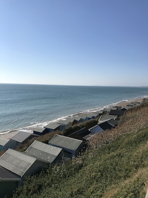 A coastal view with beach huts and a clear sky. - Vinegar Hill Pottery B & B (Lymington)