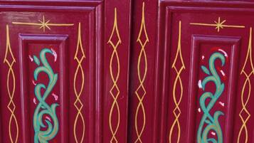 A set of red doors with intricate gold and teal designs.