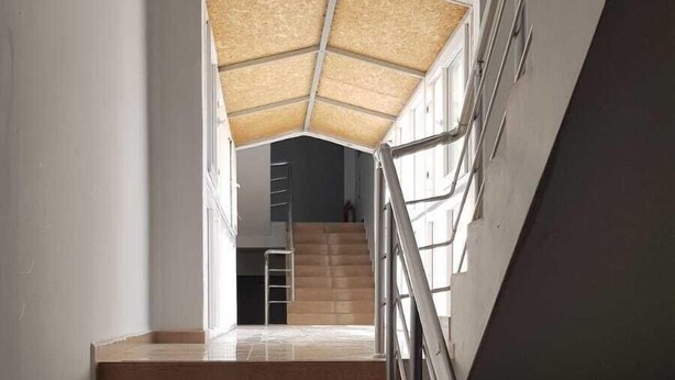 A staircase with a metal railing, leading to a landing with a ceiling covered in a translucent material. - Aslan Apart Otel (Aydincik)