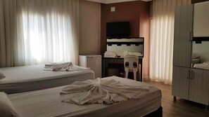 A hotel room with two beds, a desk, a television, and a wardrobe. - Aslan Apart Otel (Aydincik)