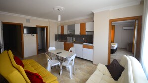 A compact living space with a dining area, kitchenette, and a sofa. - Aslan Apart Otel (Aydincik)