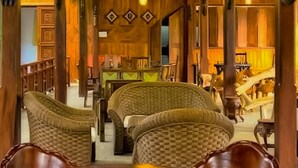 A wooden interior with a round table and wicker chairs. - Silver Crown Nature Resort (Anuradhapura)