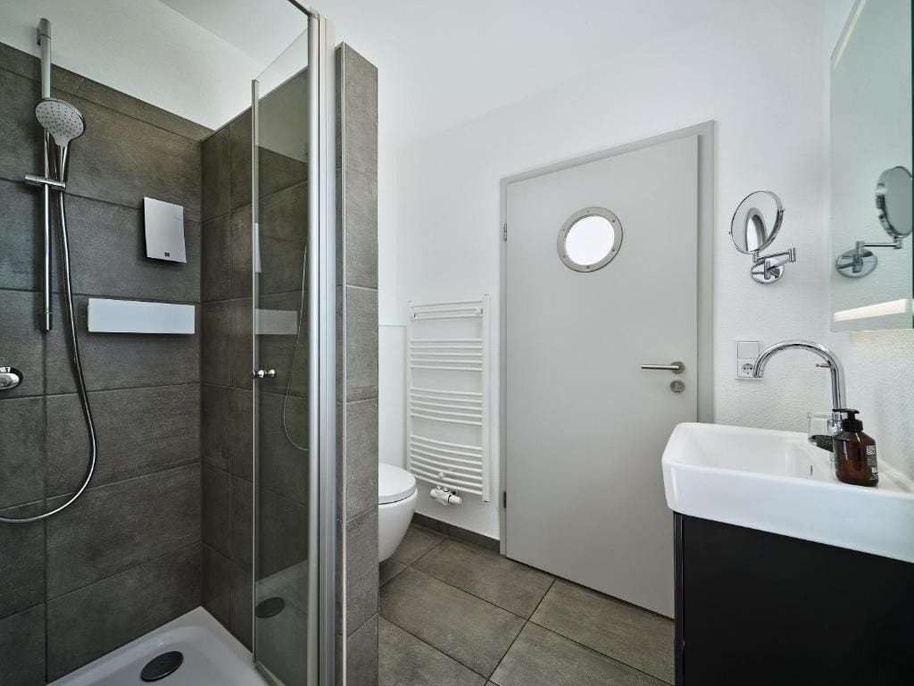 A modern bathroom with a shower, toilet, and sink.