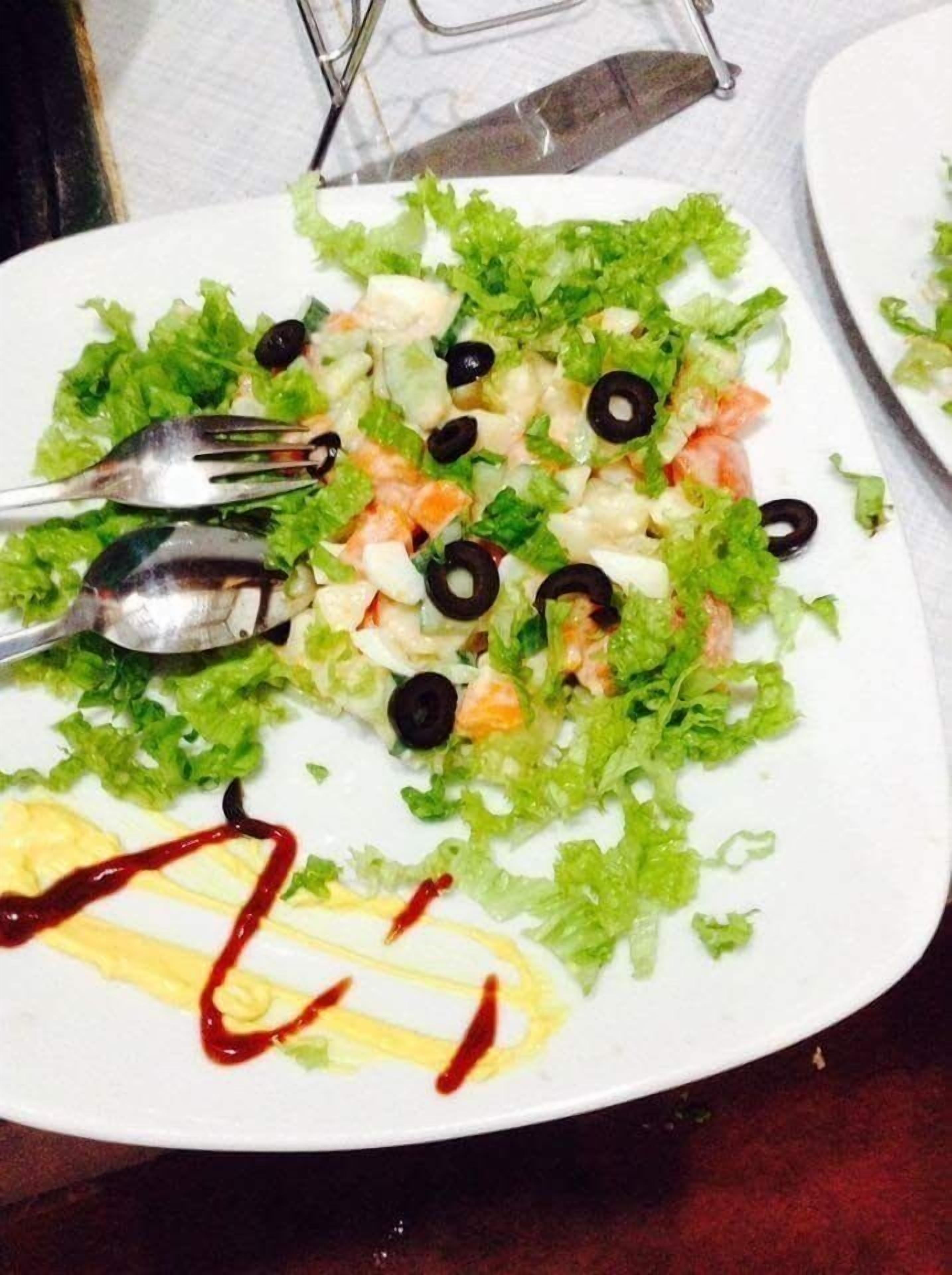 Ensalada con lechuga, aceitunas negras y un aderezo ligero.