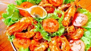 Una ensalada con lechuga, tomates y camarones.