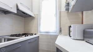 Una cocina moderna con estufa a gas, horno empotrado y tostadora.