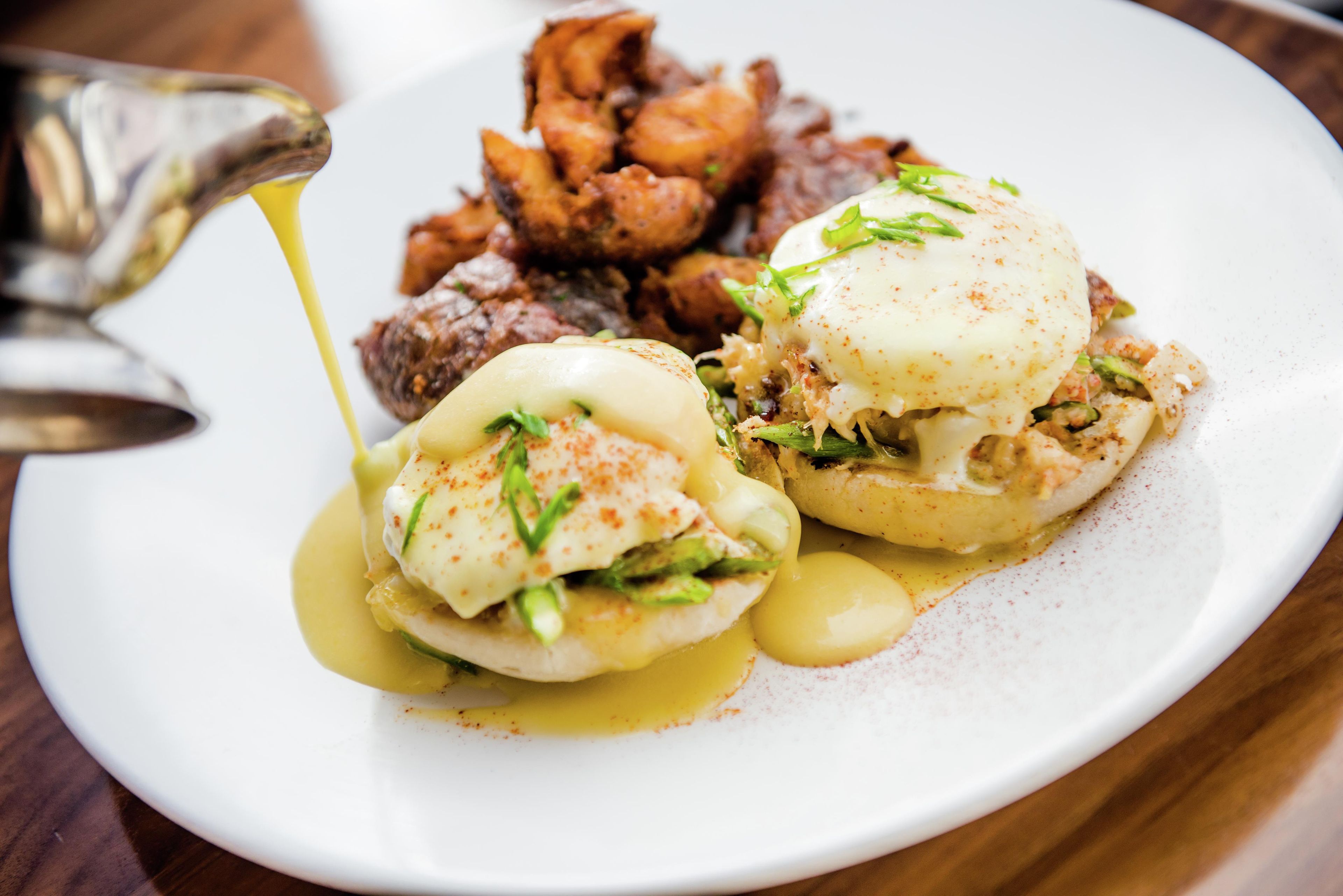 Un plato de comida con huevos, vegetales verdes y salsa.