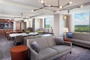 Une chambre d’hôtel moderne dotée d’un coin repas, d’un canapé et offrant une vue sur le paysage.