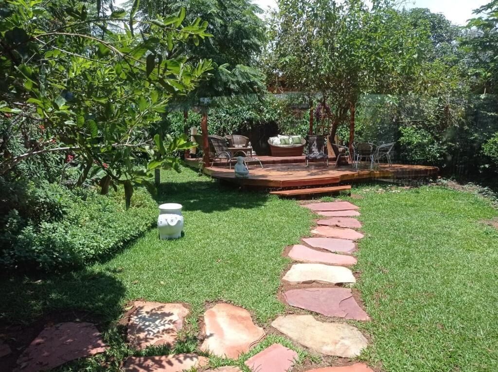 Ein Garten mit einem gepflasterten Weg, der zu einer Sitzgruppe mit Stühlen und einem Tisch führt.