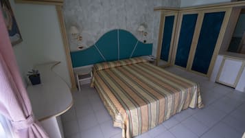 Un dormitorio con cama, mesitas de noche, escritorio y armario.