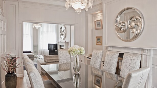 A formal dining room with a chandelier, a fireplace, and a large mirror. - The Bono Suite- hiphipstay (Dublin)