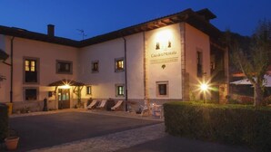 A building with a sign reading "Casa de la Montaña" and a paved courtyard with outdoor seating. - Casa de la Montaña (Onis)